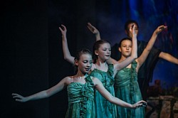 Three girls in green dresses dancing